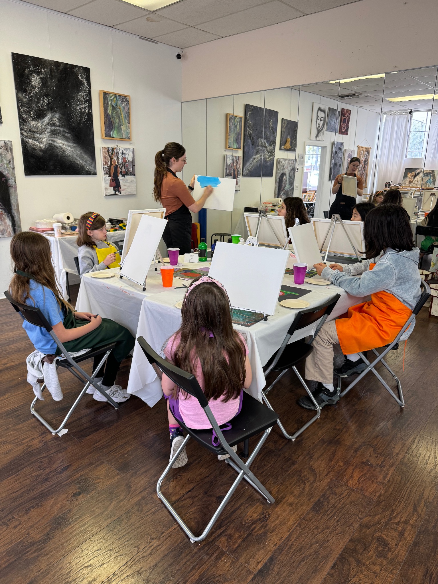 Workshop participants painting at easels during a Margolis Arts Foundation community education event.